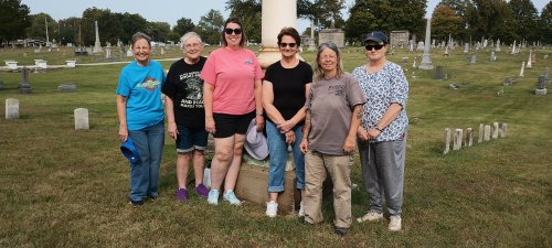 Cleaning headstones at Elmwood Cemetery